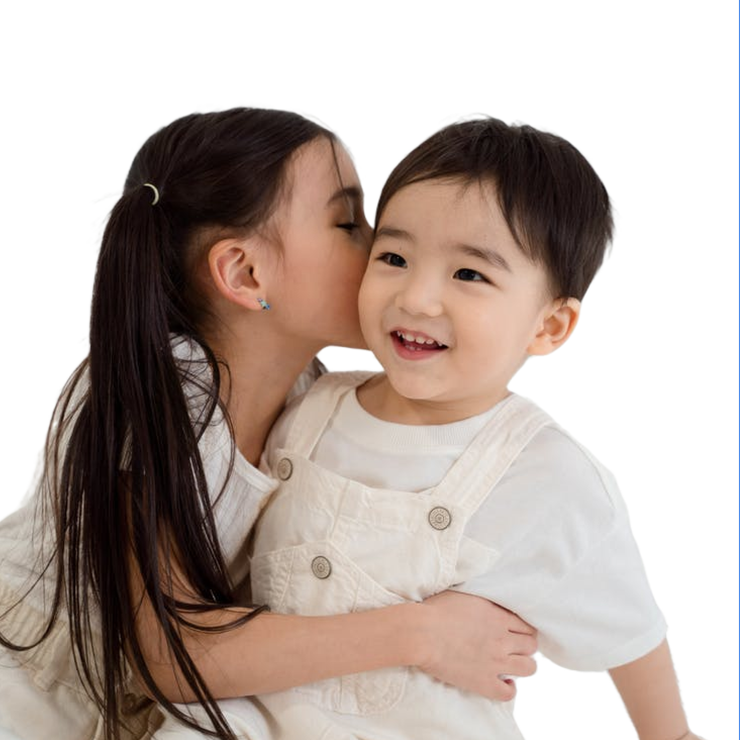 A girl is hugging and kissing a smiling baby boy